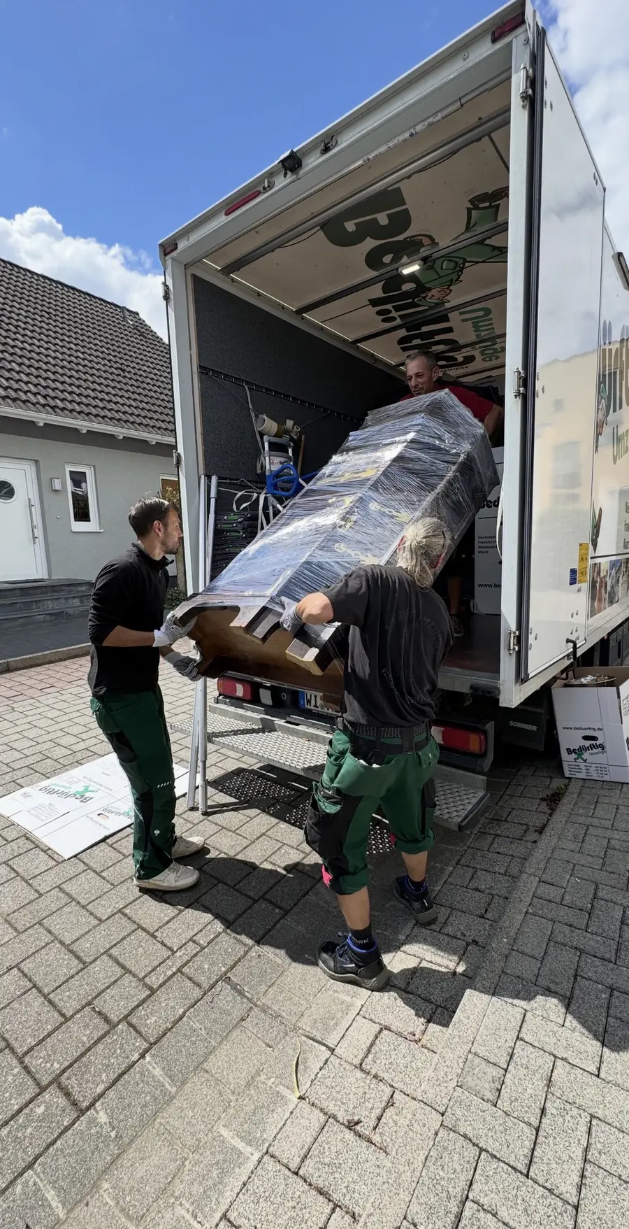 Team von Bedürftig Umzüge verlädt ein geschütztes Möbelstück für die Einlagerung