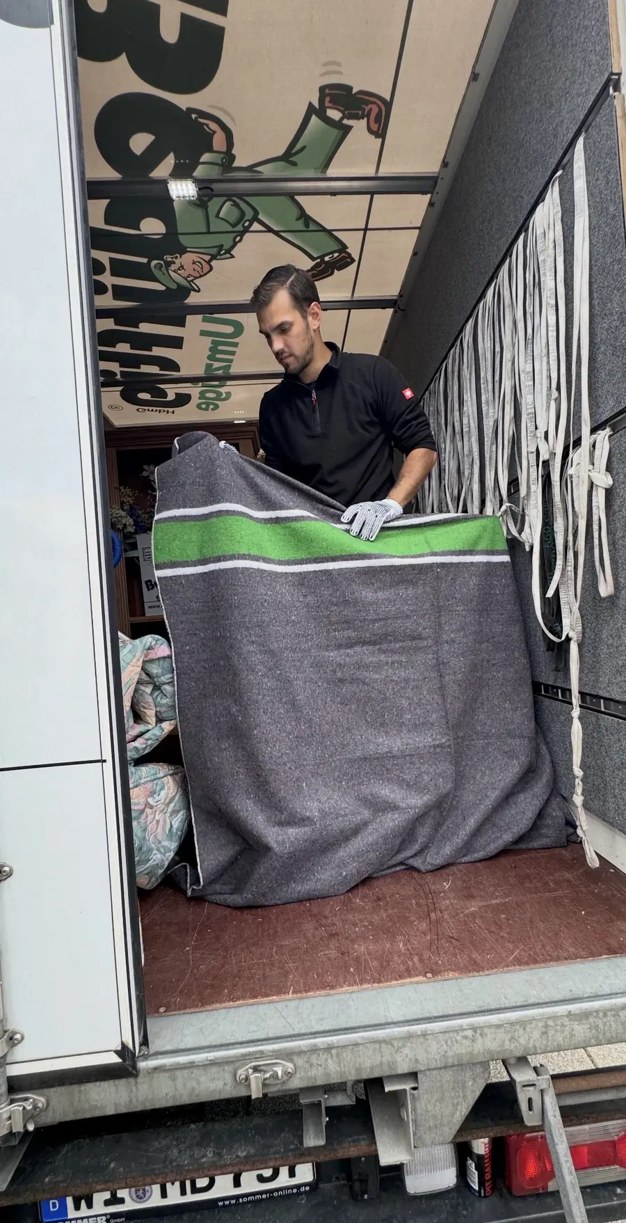 Umzugsmitarbeiter verpackt Möbel für Transport und Lagerung
